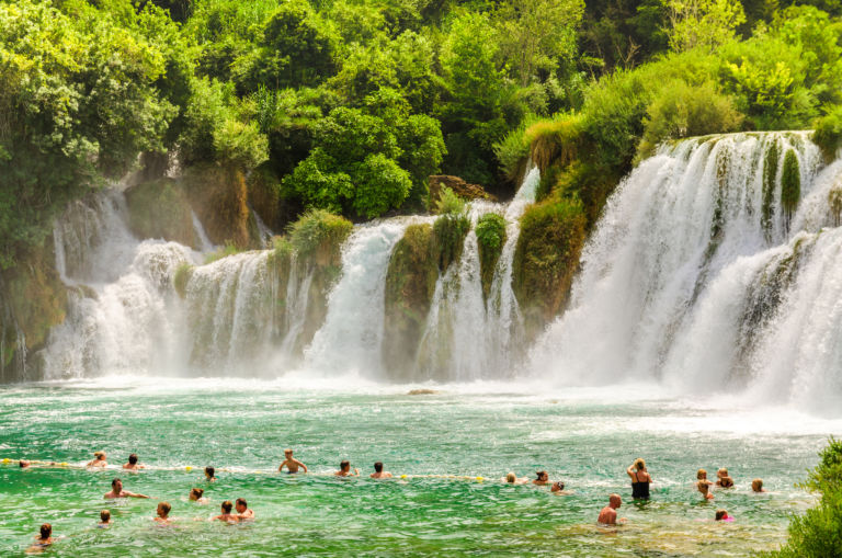 Waterfalls of Krka National Park, Dalmatia / Croatia - 21 July 2014: Tourists swimming near waterfalls in crystal clear water. Tourist spot in Dalmatia Krka National Park, place to go and visit